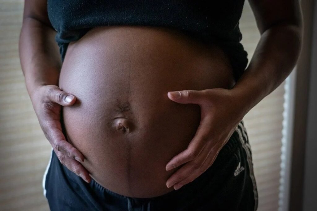 Close-up of pregnant belly with hands