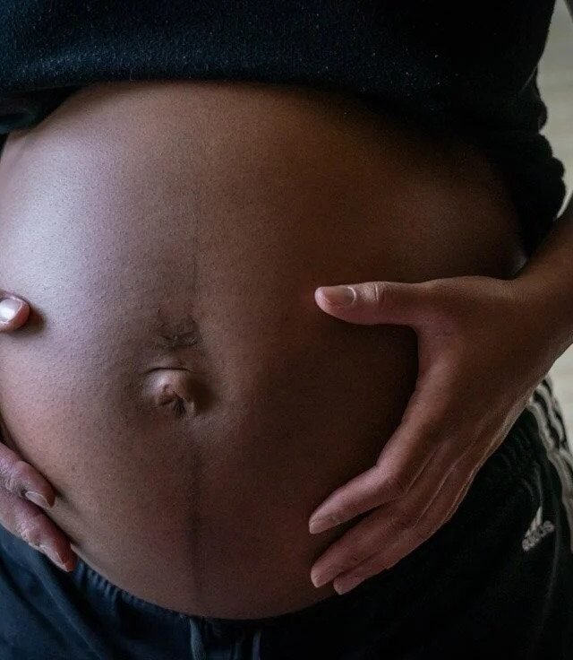 Close-up of pregnant belly with hands